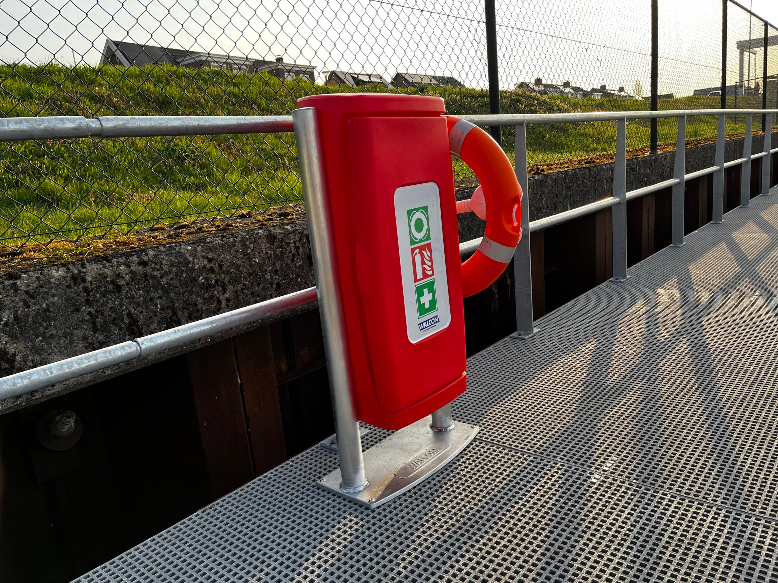 Walcon veiligheid box met reddingsboei, geplaatst op een steiger met hekwerk langs het water.