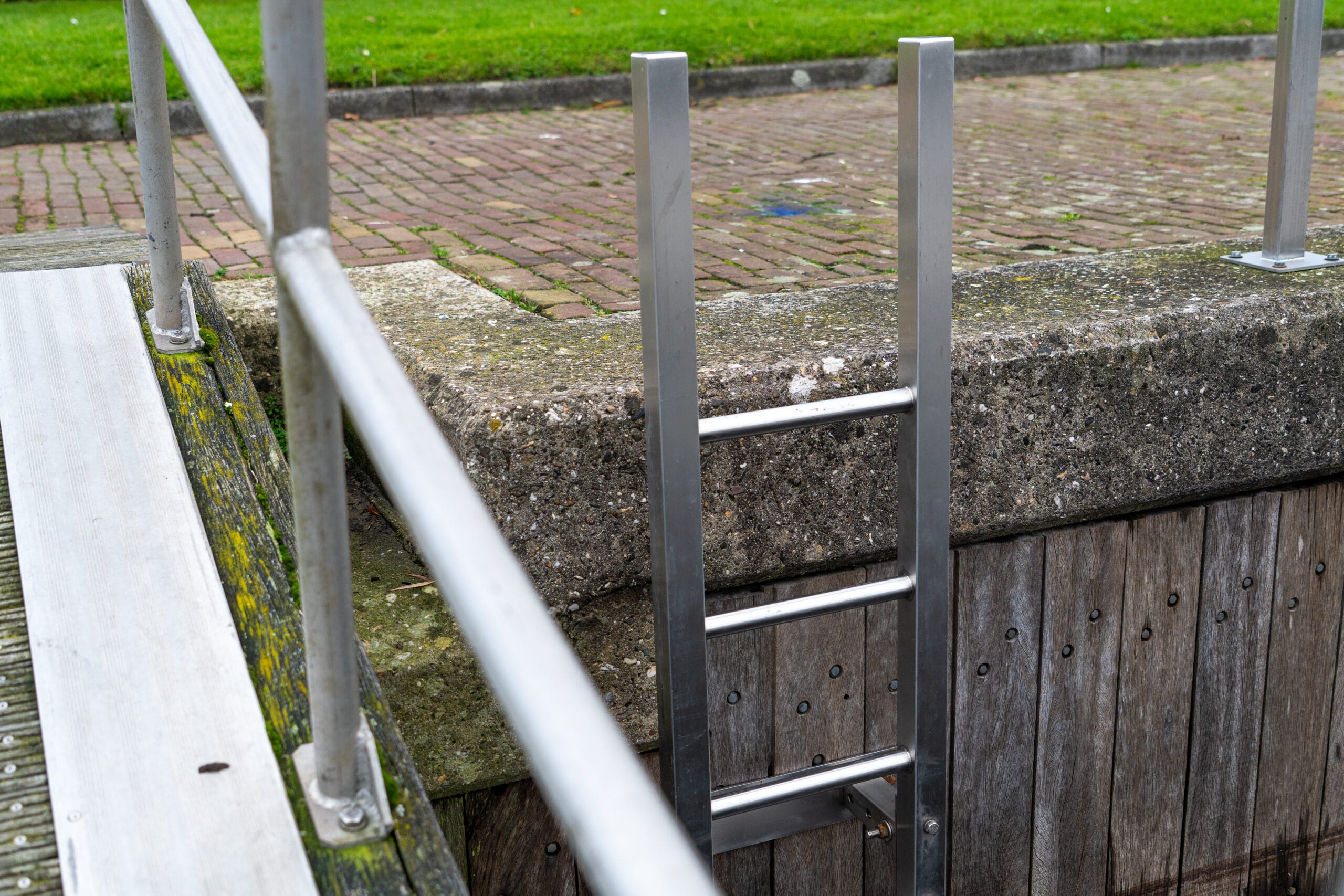 Volledige weergave van een RVS veiligheidsladder geïnstalleerd aan een kade