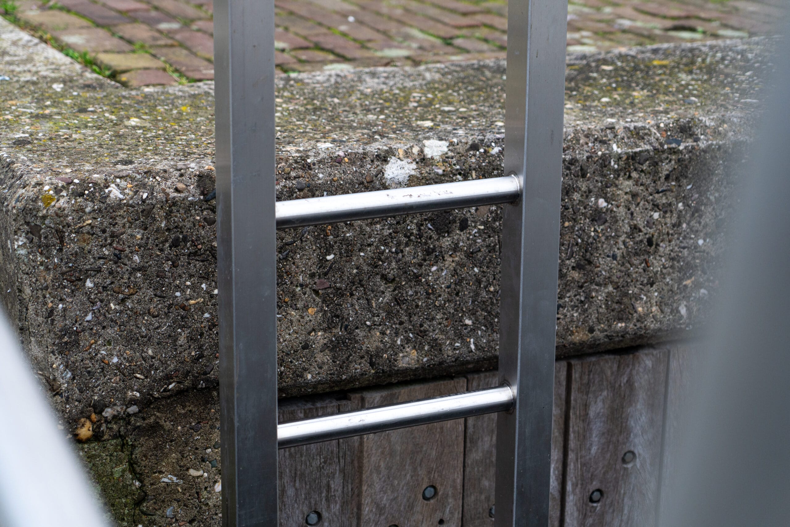  Close-up van een RVS veiligheidsladder, bevestigd aan een steiger voor optimale stevigheid.