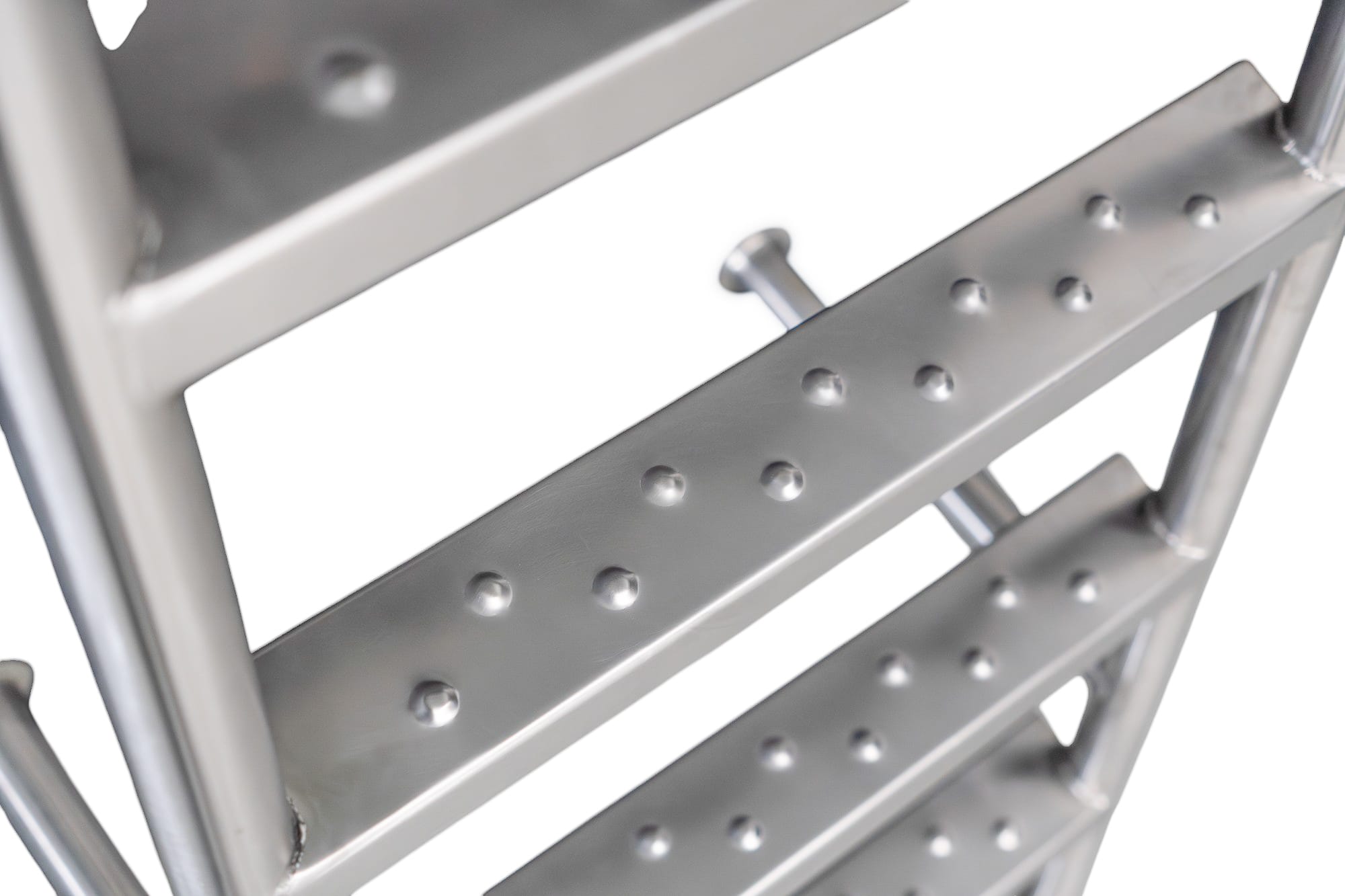 Detailopname van een roestvrijstalen ladder met antislip treden en bevestigingspunten.