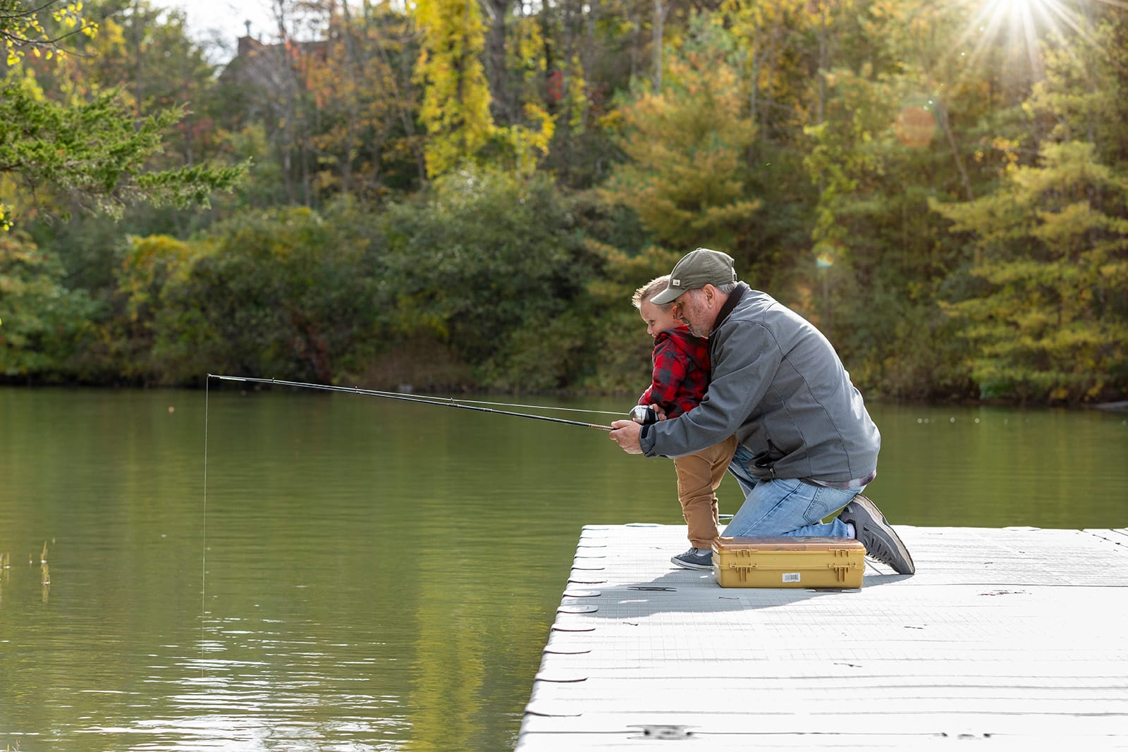  Grootvader en kleinzoon vissen samen vanaf een EZ Dock kunststof drijvende steiger aan het meer
