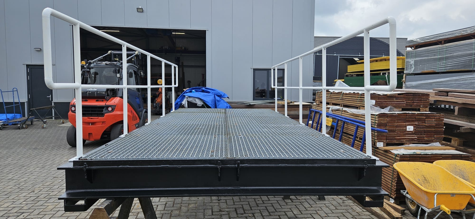 Gebrauchte Schwerlastgangway mit Stahlgitterrostbelag und weißem Geländer, Frontansicht