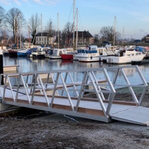 Aluminiumweg mit Holzdeck und Handläufen, die in einem Yachthafen am Steg gestellt werden