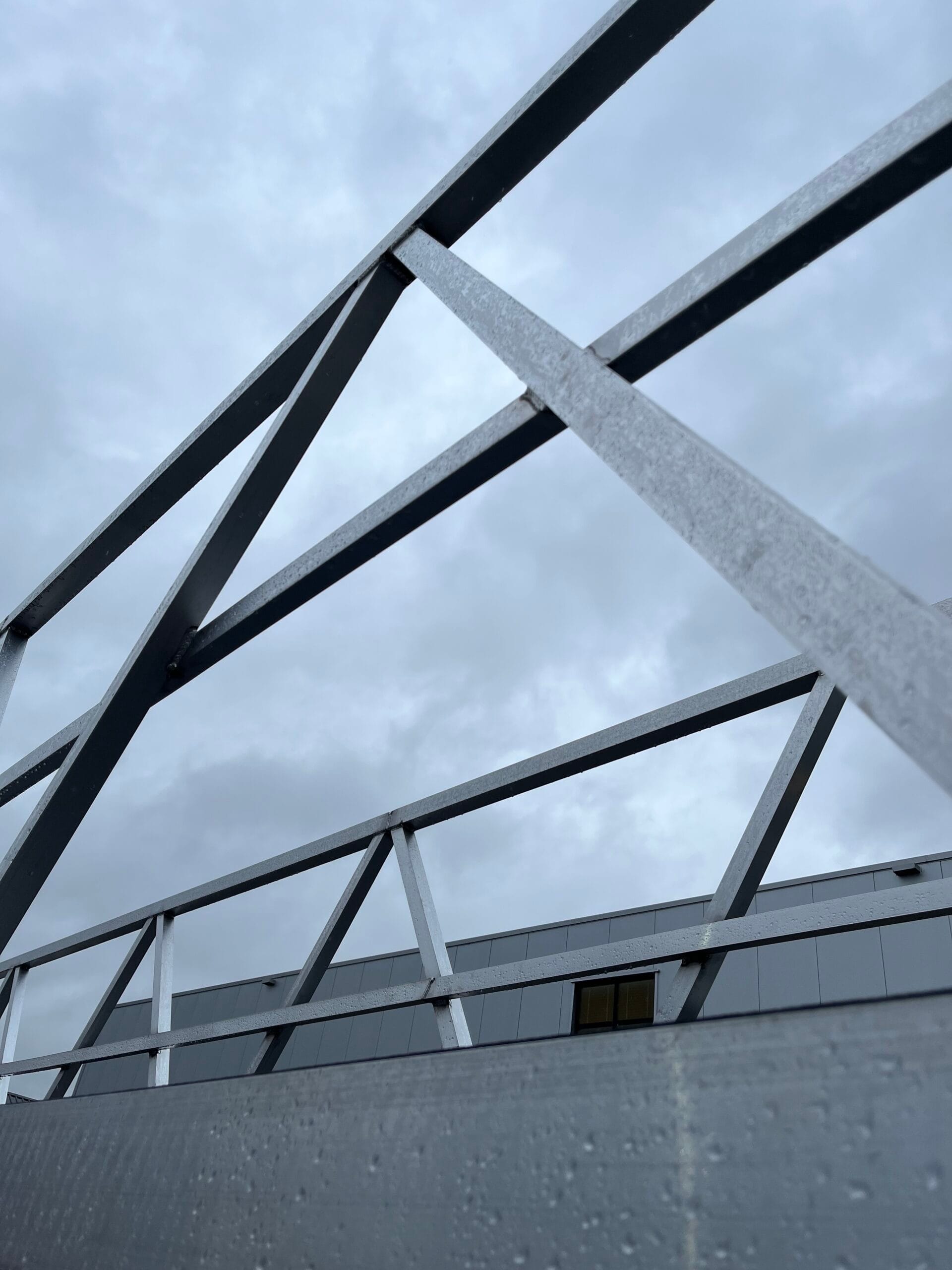 Aluminum walkway with diagonal rods under a cloudy air with gray clouds.