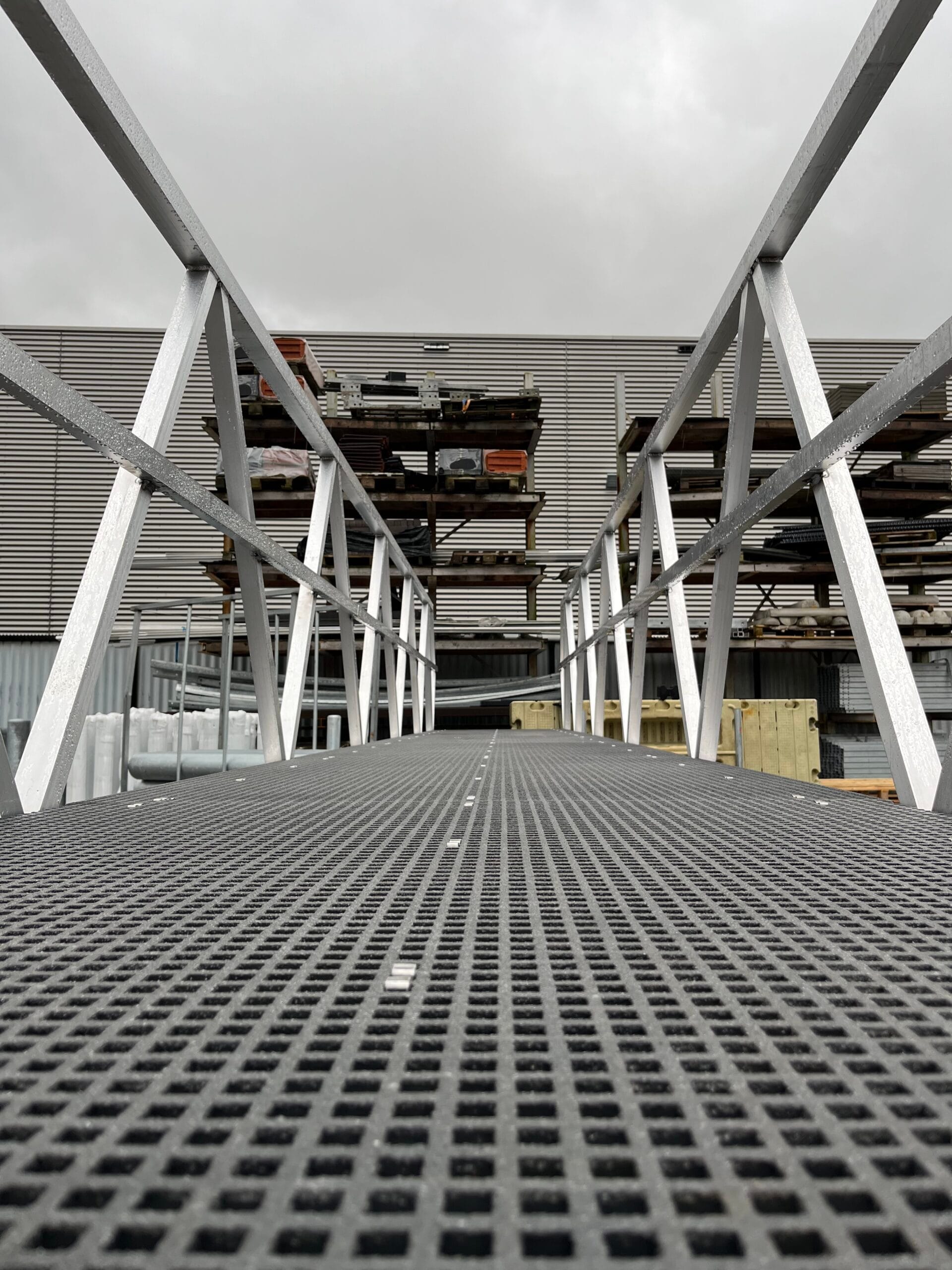 Aluminum walkway with plastic anti -slip walking deck and handrails, seen from the walkway