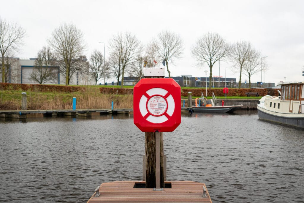 Reddingsboeikast op een open steiger, direct toegankelijk vanaf de waterkant.
