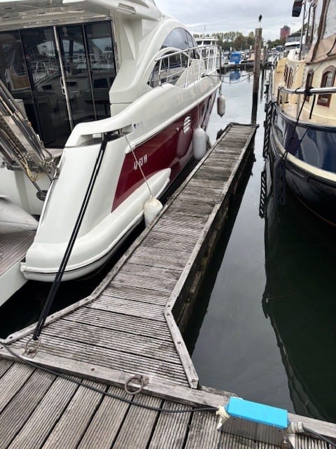  Houten Havenhout vingerpier drijvend in een jachthaven, aangemeerd aan hoofdsteigerVingerpier van de gebruikte Havenhout steigerset; beschikbaar medio januari/februari 2026.
