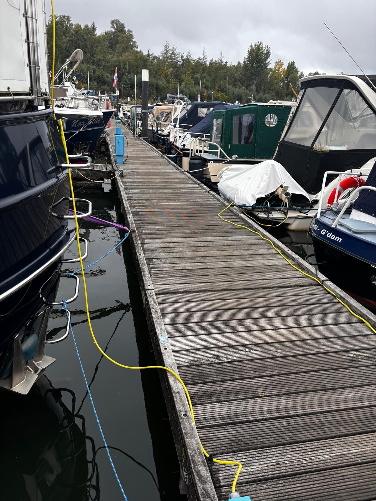  Zijaanzicht van een drijvende houten hoofdsteiger van het merk Havenhout in een jachthaven